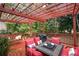 Beautiful outdoor deck with red wood, outdoor seating with red cushions, and a pergola at 4651 Oakleigh Manor Dr, Powder Springs, GA 30127