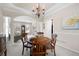 Bright dining room with elegant columns, a wooden table set for four, and a seamless transition into the living area at 4651 Oakleigh Manor Dr, Powder Springs, GA 30127