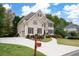 Well-maintained home boasts a spacious driveway and mature trees, set against a backdrop of blue skies and lush greenery at 4651 Oakleigh Manor Dr, Powder Springs, GA 30127