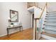 Elegant foyer with hardwood floors, staircase with white railings, and a stylish console table with decorative mirror at 4651 Oakleigh Manor Dr, Powder Springs, GA 30127