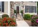 Close-up of a welcoming front entrance with stone steps and a manicured landscape featuring vibrant red and pink azaleas at 4651 Oakleigh Manor Dr, Powder Springs, GA 30127
