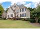 Charming two-story home featuring stone accents and a beautifully landscaped front yard with lush greenery and colorful flowers at 4651 Oakleigh Manor Dr, Powder Springs, GA 30127