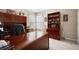 Well-lit home office with a large desk, built-in shelves, and two bright windows at 4651 Oakleigh Manor Dr, Powder Springs, GA 30127