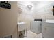 Functional laundry room with sink, shelving, and washer/dryer at 4651 Oakleigh Manor Dr, Powder Springs, GA 30127