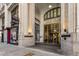 A detailed view of the building's entrance with brass doors, historical signage, and stone columns at 57 Forsyth Nw St # 9G, Atlanta, GA 30303