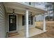 Covered front porch with white columns, stylish lighting, and a 'Welcome' mat at 111 Jackson Farms Dr, Rockmart, GA 30153