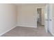 Cozy bedroom with neutral walls and carpet, featuring a view of another room through an open door at 6557 Snow Bird Ln, Douglasville, GA 30134