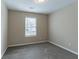 Neutral bedroom features a window and plush carpeting at 6557 Snow Bird Ln, Douglasville, GA 30134