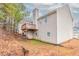 Two-story home featuring a wooden deck and beige siding, nestled among mature trees at 6557 Snow Bird Ln, Douglasville, GA 30134