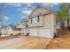 View of the two car garage, driveway, and landscaping on this cozy two-story home at 6557 Snow Bird Ln, Douglasville, GA 30134