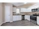 Well-lit kitchen with stainless steel appliances, granite countertops and white cabinets at 6557 Snow Bird Ln, Douglasville, GA 30134