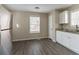 Bright kitchen featuring stainless steel refrigerator, wood floors, granite countertops, and modern white cabinets at 6557 Snow Bird Ln, Douglasville, GA 30134