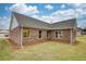 A private backyard oasis with verdant grass, and brick-veneer exterior with white trim windows at 711 Park Place Way, Social Circle, GA 30025