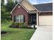 Beautiful single-story home with a well-manicured lawn, manicured garden beds and a freshly poured concrete driveway at 2147 Red Oak Cir, Union City, GA 30291