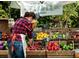 A farmer's market stall with fresh produce and a vendor arranging items for sale at 2637 Mackintosh Ct # 8, Brookhaven, GA 30319