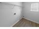 Bright laundry room with shelving, window, and wood-look flooring at 4441 Prather Son Dr, Loganville, GA 30052