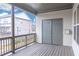 Covered deck featuring a gray wood floor, a white wall, gray doors, and a view to the neighboring house at 1430 Baygreen Rd, Suwanee, GA 30024