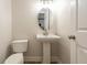 This powder room features an oval mirror, a pedestal sink, and wood-look flooring at 1521 Reids Ferry Way, Marietta, GA 30062