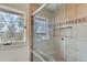 Bathroom featuring large tiles, glass shower doors and a window looking out to a lake at 4110 Sinclair Shores Rd, Cumming, GA 30041