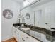 Bathroom featuring long vanity with granite countertops, white cabinets and a large mirror at 4110 Sinclair Shores Rd, Cumming, GA 30041