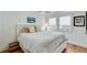 Bright bedroom with white bedding, wood flooring, and a large window for natural light at 4110 Sinclair Shores Rd, Cumming, GA 30041