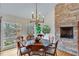 Charming dining room with stone fireplace and ample sunlight from picture windows overlooking the landscape at 4110 Sinclair Shores Rd, Cumming, GA 30041