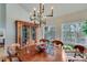 Elegant dining room featuring a round table, stylish chandelier, and display cabinet, with natural light and views at 4110 Sinclair Shores Rd, Cumming, GA 30041