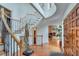 Grand foyer with wood staircase and floors leads into living spaces with stone fireplace and bright windows at 4110 Sinclair Shores Rd, Cumming, GA 30041