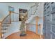 Elegant foyer showcasing a curved staircase, wood floors and custom metal art sculpture at 4110 Sinclair Shores Rd, Cumming, GA 30041