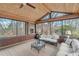 Cozy screened porch with brick fireplace, wood floors, and white wicker furniture at 4110 Sinclair Shores Rd, Cumming, GA 30041