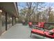 A deck with a gray surface has a red cushioned lounge chair and views of the surrounding trees at 4230 N Elizabeth Se Ln, Atlanta, GA 30339