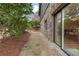 A walkway on the side of a stone and wooden house, with lush green foliage and mulch at 4230 N Elizabeth Se Ln, Atlanta, GA 30339