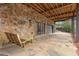 An outdoor patio with stone flooring and a stone wall is complete with a porch swing at 4230 N Elizabeth Se Ln, Atlanta, GA 30339