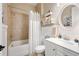 Bright bathroom featuring a shower-tub combination with a white vanity and round mirror at 515 Windy Ridge Ct, Canton, GA 30114