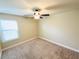 Neutral bedroom featuring tan walls, plush carpet, ceiling fan, and a window at 2378 Misty Ivy Ct, Buford, GA 30519