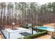 View of a fenced basketball court, framed by manicured hedges, with the pool in the background at 3201 Hobsons Ridge Nw Trl, Acworth, GA 30101