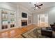 Elegant living room featuring a fireplace with a TV, hardwood floors, and french doors leading to a backyard pool at 3201 Hobsons Ridge Nw Trl, Acworth, GA 30101