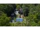 Aerial view of a stunning estate featuring a pool, gardens, tennis court, and wooded surroundings at 4000 Conway Valley Nw Rd, Atlanta, GA 30327