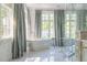 Bright bathroom with freestanding tub, large windows, and elegant marble flooring at 4000 Conway Valley Nw Rd, Atlanta, GA 30327