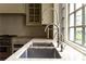 Close up of the double sink, granite countertop, and stainless steel fixtures next to a bright window at 4000 Conway Valley Nw Rd, Atlanta, GA 30327