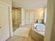 Modern bathroom with a glass shower, soaking tub, and tile flooring at 4188 Gunnerson Ln, Kennesaw, GA 30152