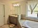 Bright bathroom with a large window, soaking tub, and vanity with granite countertops at 4188 Gunnerson Ln, Kennesaw, GA 30152