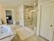 Bright bathroom featuring a glass-enclosed shower, a soaking tub, and neutral tile at 4188 Gunnerson Ln, Kennesaw, GA 30152