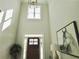 Two-story foyer with dark wood front door, featuring modern decor and ample natural light at 4188 Gunnerson Ln, Kennesaw, GA 30152