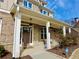 Inviting covered front porch with brick accents, columns, and stylish lighting fixtures at 4188 Gunnerson Ln, Kennesaw, GA 30152