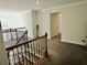 Upstairs hallway boasts sleek black wrought iron railing and neutral gray carpet throughout at 4188 Gunnerson Ln, Kennesaw, GA 30152
