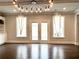 Bright living room boasts hardwood floors, a modern chandelier, and glass patio doors at 4188 Gunnerson Ln, Kennesaw, GA 30152