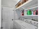 Functional laundry room with washer, dryer, shelving, and ample storage space at 5835 Sterling Ct, Cumming, GA 30040