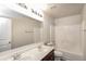 This bathroom includes double sinks, a large mirror, white cabinets, and a bath/shower combo at 4924 Rapahoe Trl, Atlanta, GA 30349
