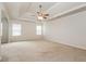 Spacious main bedroom with plush carpet, tray ceiling, fan, and ample natural light at 4924 Rapahoe Trl, Atlanta, GA 30349